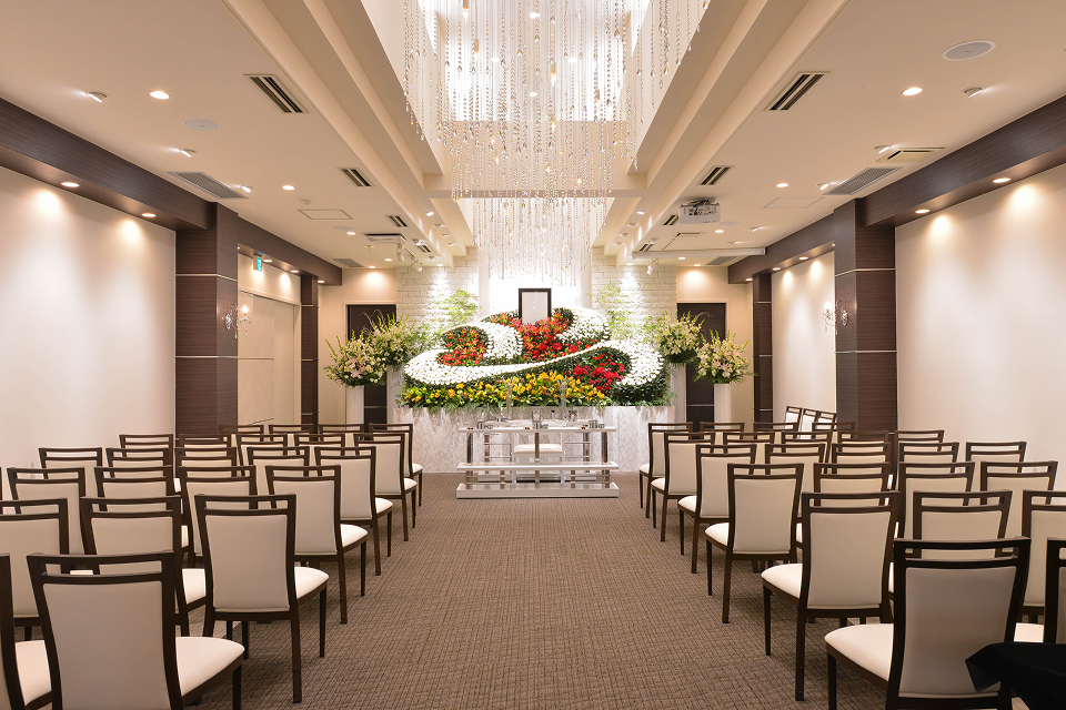 さいたま市のオーロラ・ホール中央の祭壇前に並んだ椅子で博愛社が葬儀を執り行う式場風景